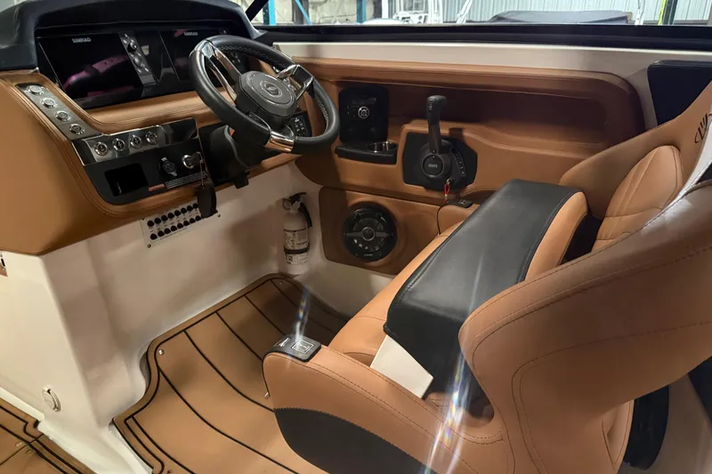 Slide: The Image of 2022 Chaparral 307 SSX boat interior with tan leather seating and modern dashboard controls. - 8