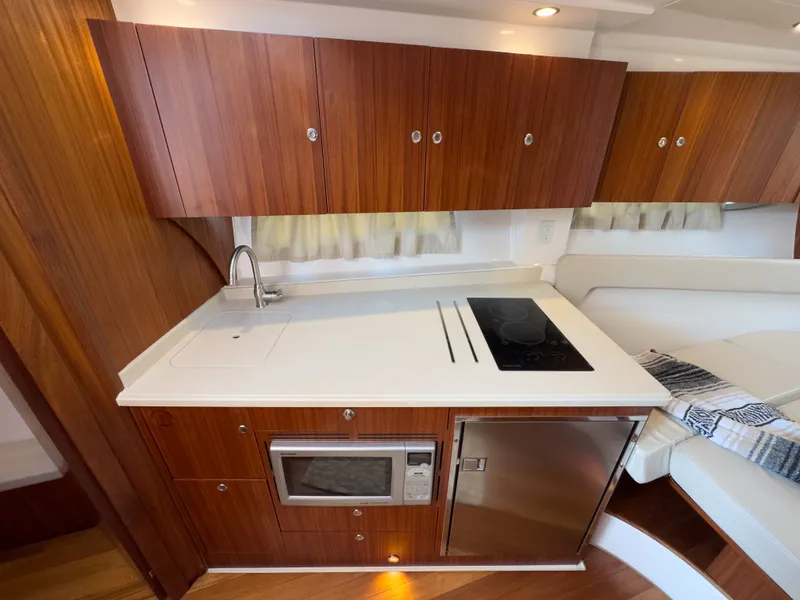 Slide: The Image of 2015 Pursuit SC 365i Sport Coupe kitchen area with wooden cabinets. - 29