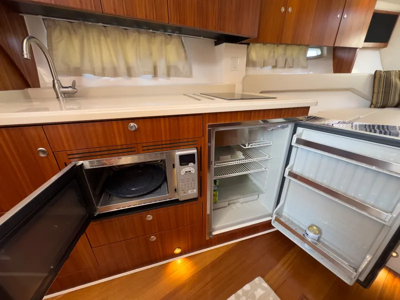 Slide: The Image of Kitchen area in 2015 Pursuit SC 365i Sport Coupe with microwave and fridge. - 31