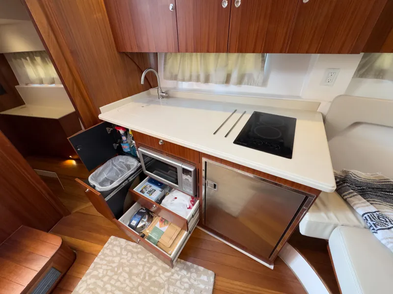 Slide: The Image of 2015 Pursuit SC 365i Sport Coupe kitchen area with wooden cabinets. - 32