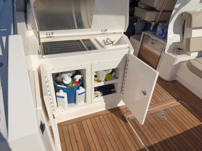 Slide: The Image of 2015 Pursuit SC 365i Sport Coupe with open storage compartment and cleaning supplies. - 7