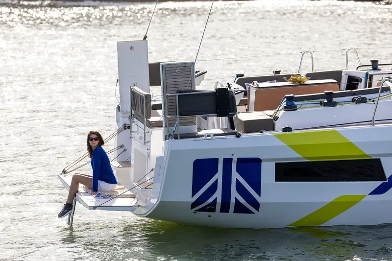 Slide: The Image of 2025 Dufour 44 yacht with person sitting on deck, modern design, vibrant graphics. - 21