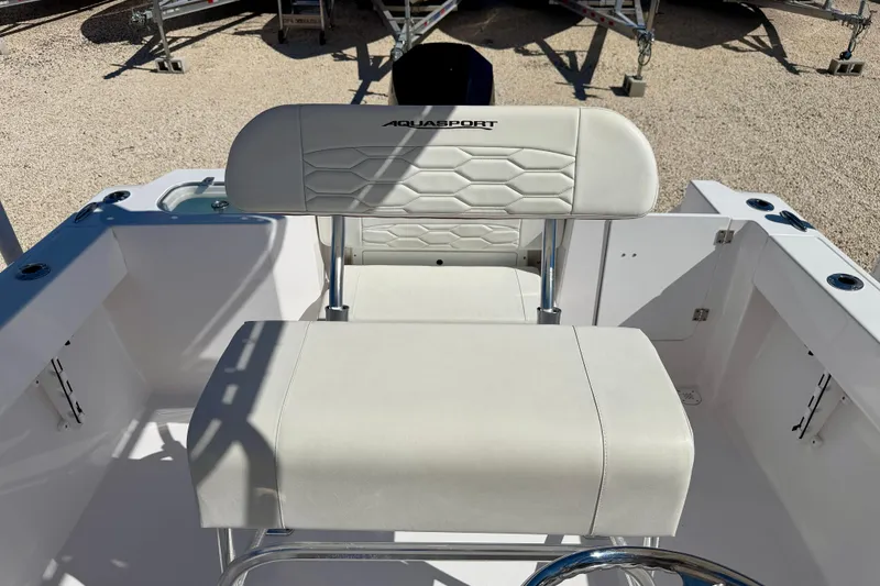 Slide: The Image of 2023 Aquasport 2200 Center Console boat seating with white upholstery and chrome accents. - 14