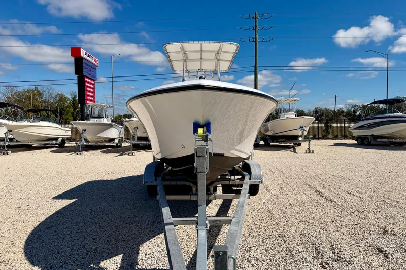 Slide: The Image of 2023 Aquasport 2200 Center Console boat on trailer at dealership under blue sky. - 2
