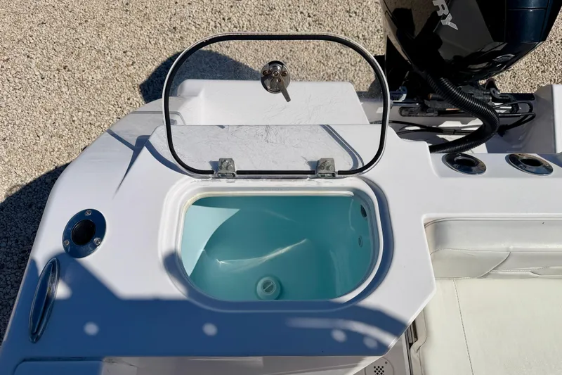 Slide: The Image of 2023 Aquasport 2200 Center Console boat with open storage compartment and engine view. - 25