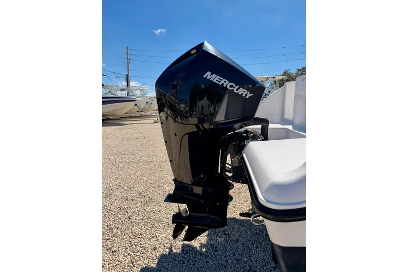 Slide: The Image of 2023 Aquasport 2200 Center Console with Mercury outboard motor in a sunny outdoor setting. - 27