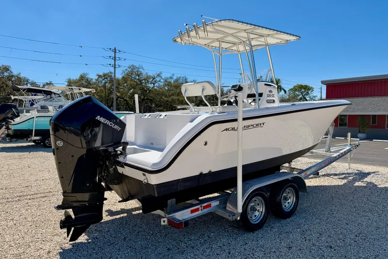 Slide: The Image of 2023 Aquasport 2200 Center Console boat on trailer, featuring Mercury outboard engine. - 5