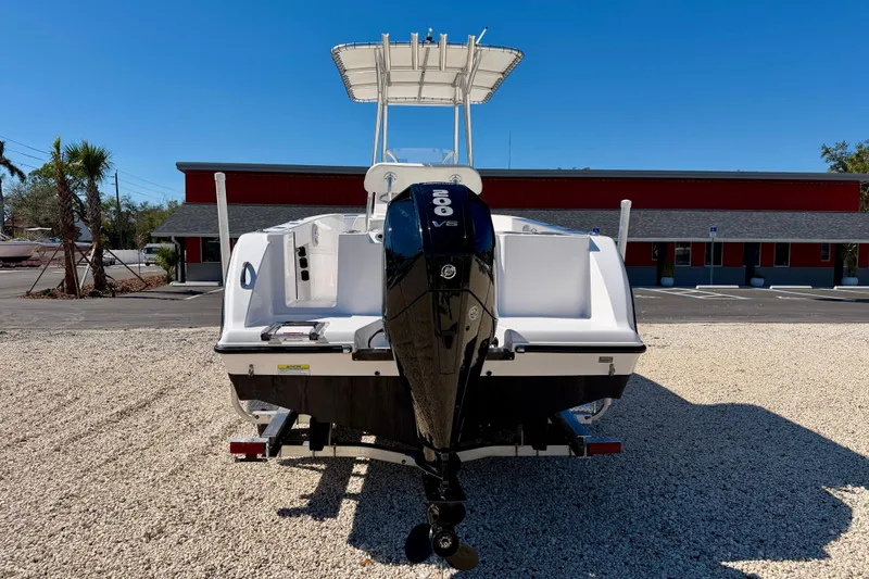 Slide: The Image of 2023 Aquasport 2200 Center Console boat with powerful outboard motor, parked on gravel. - 6