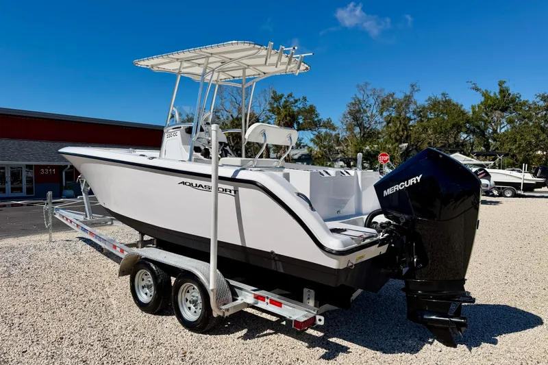 Slide: The Image of 2023 Aquasport 2200 Center Console boat on trailer with Mercury engine, outdoor display. - 7