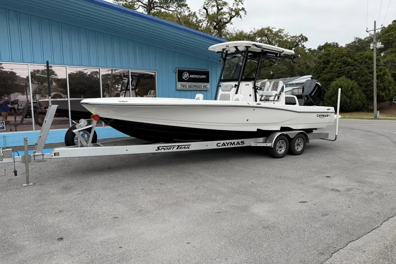 The Image of 2026 Caymas 28 HB boat on trailer outside a blue building. - 0
