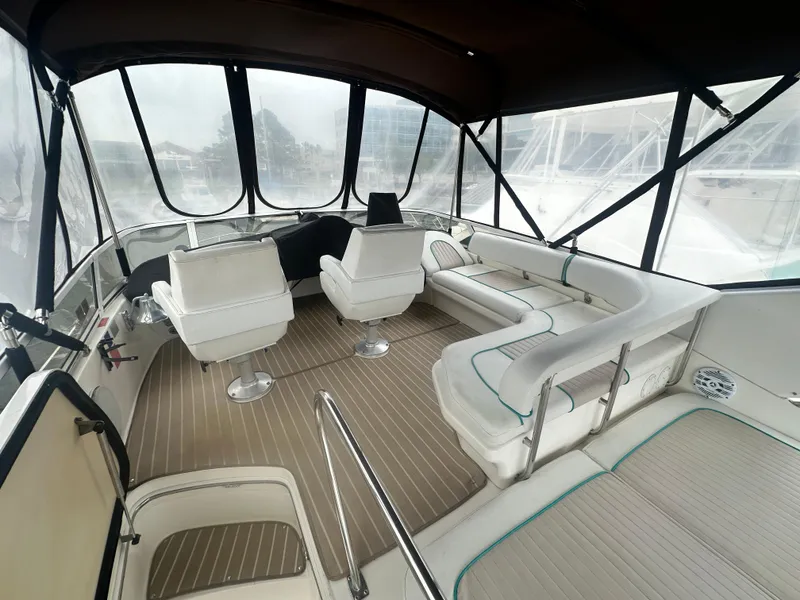 Slide: The Image of 1997 Sea Ray 400 Sedan Bridge interior with seating and helm, featuring panoramic windows. - 13