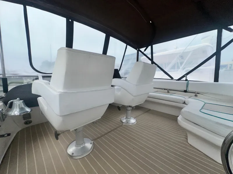Slide: The Image of 1997 Sea Ray 400 Sedan Bridge interior with white seating and striped flooring. - 16
