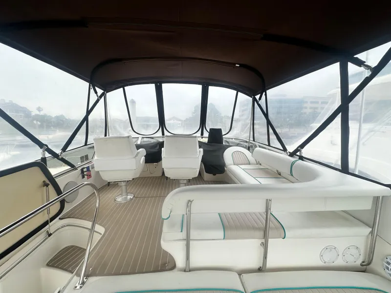 Slide: The Image of 1997 Sea Ray 400 Sedan Bridge interior with seating and helm, featuring a covered deck. - 17