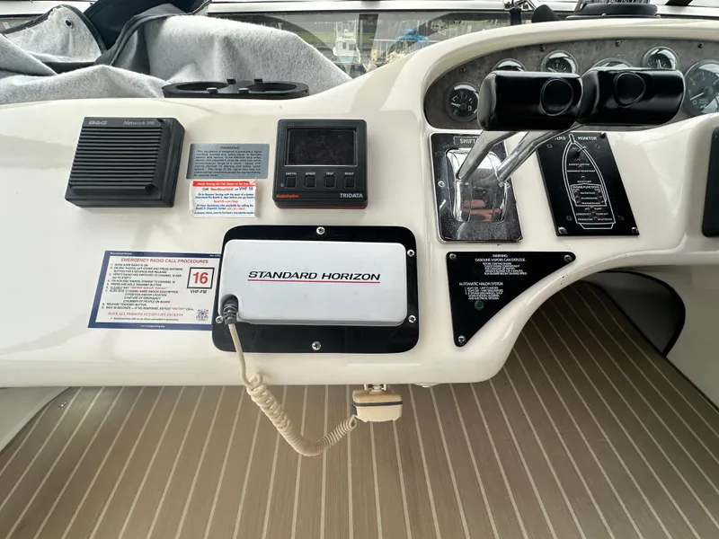 Slide: The Image of 1997 Sea Ray 400 Sedan Bridge dashboard with Standard Horizon radio and controls. - 19