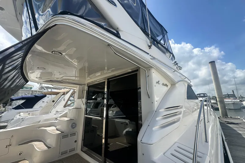 Slide: The Image of 1997 Sea Ray 400 Sedan Bridge yacht docked at marina under blue sky. - 2