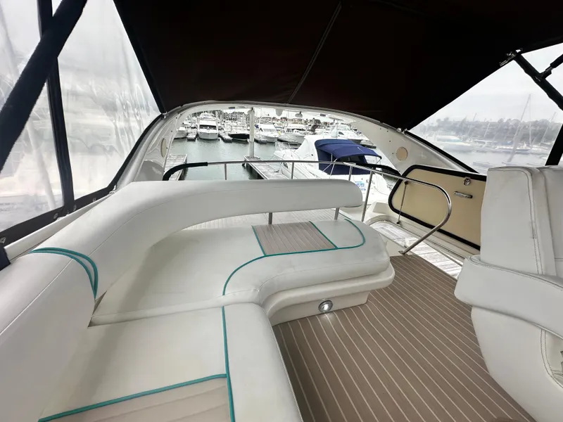 Slide: The Image of 1997 Sea Ray 400 Sedan Bridge interior with white seating and marina view. - 22