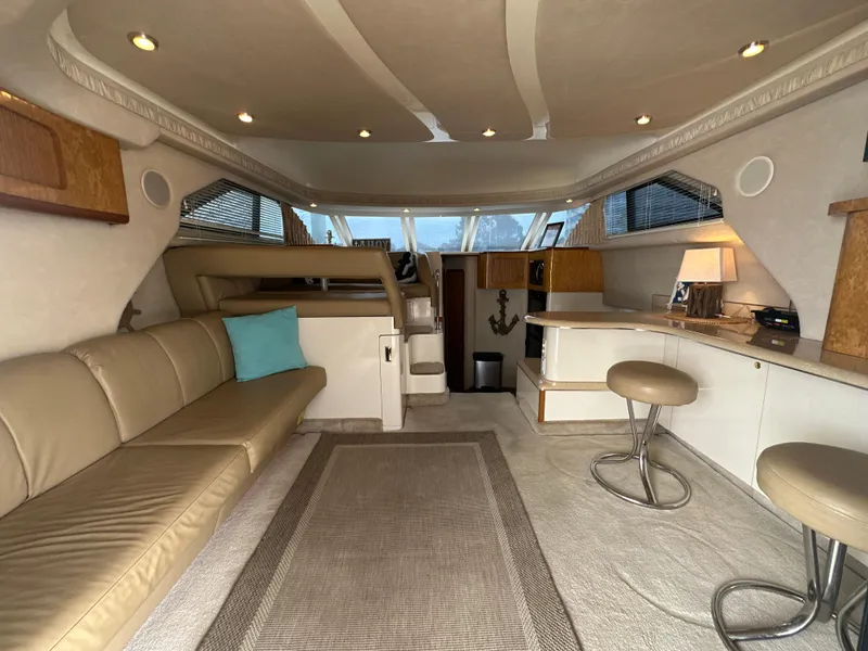 Slide: The Image of Interior of 1997 Sea Ray 400 Sedan Bridge yacht with beige seating and modern decor. - 23