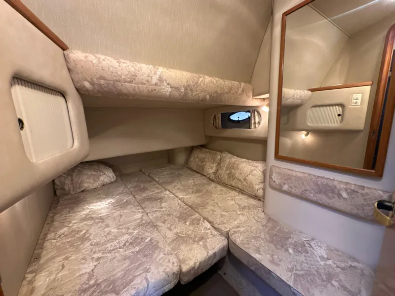Slide: The Image of 1997 Sea Ray 400 Sedan Bridge cabin with cozy bedding and mirror. - 24