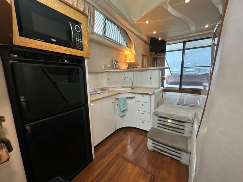Slide: The Image of Interior of 1997 Sea Ray 400 Sedan Bridge yacht with kitchen and seating area. - 26