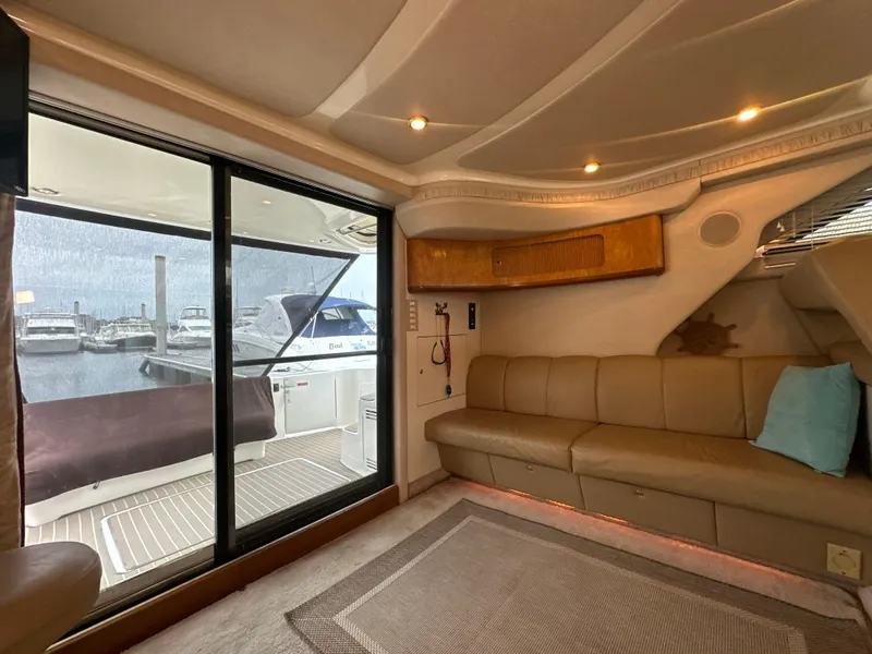 Slide: The Image of Interior of 1997 Sea Ray 400 Sedan Bridge yacht with beige seating and marina view. - 32