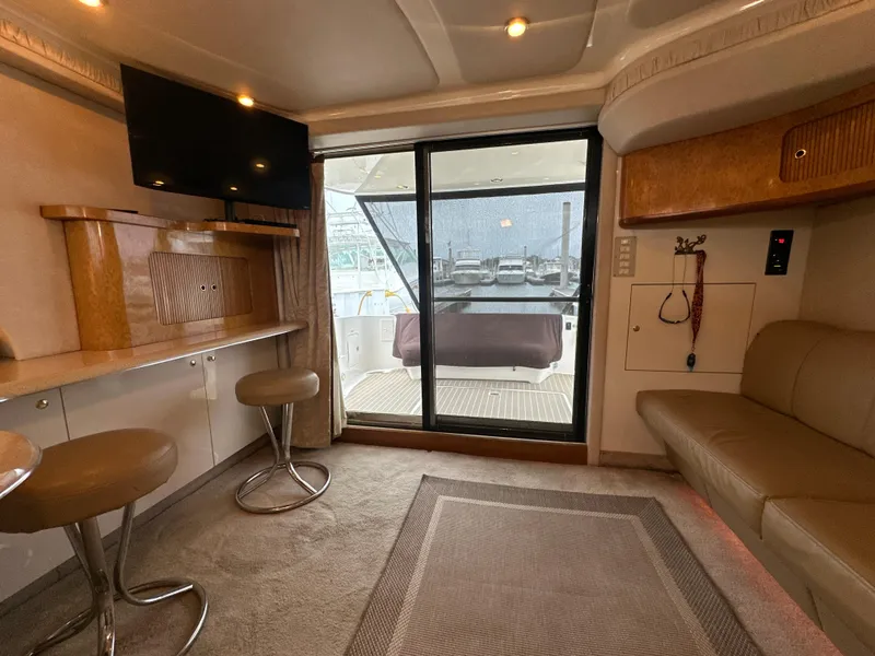 Slide: The Image of Interior of 1997 Sea Ray 400 Sedan Bridge yacht with seating, TV, and sliding glass door. - 33