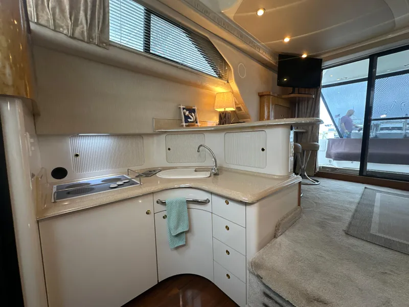 Slide: The Image of Interior of 1997 Sea Ray 400 Sedan Bridge yacht with modern kitchen and cozy living area. - 34