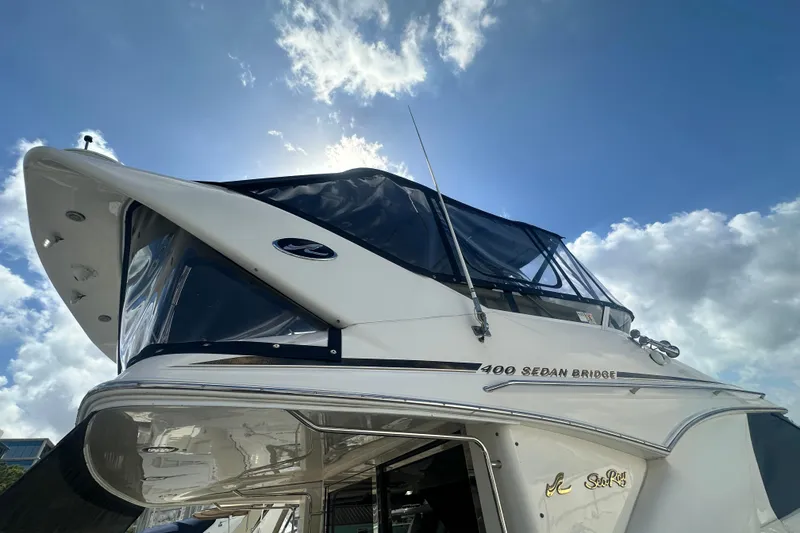 Slide: The Image of 1997 Sea Ray 400 Sedan Bridge yacht against a bright blue sky with clouds. - 4