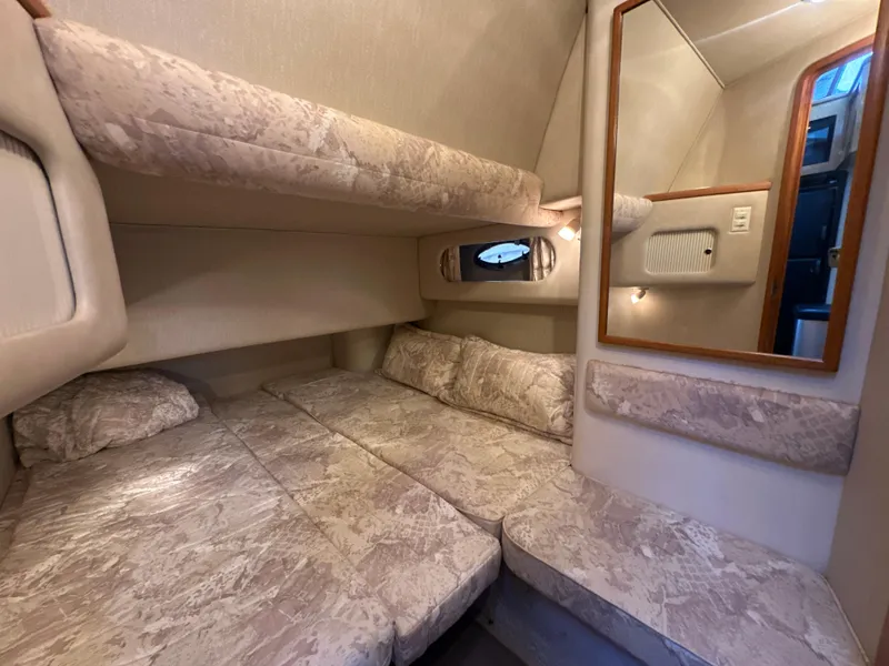 Slide: The Image of 1997 Sea Ray 400 Sedan Bridge cabin with cozy bedding and mirror. - 42