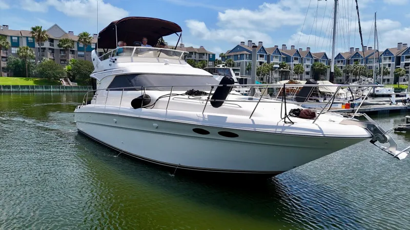Slide: The Image of 1997 Sea Ray 400 Sedan Bridge yacht docked in a marina with waterfront homes. - 5