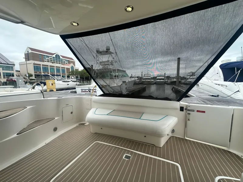 Slide: The Image of 1997 Sea Ray 400 Sedan Bridge yacht interior with seating and marina view. - 8