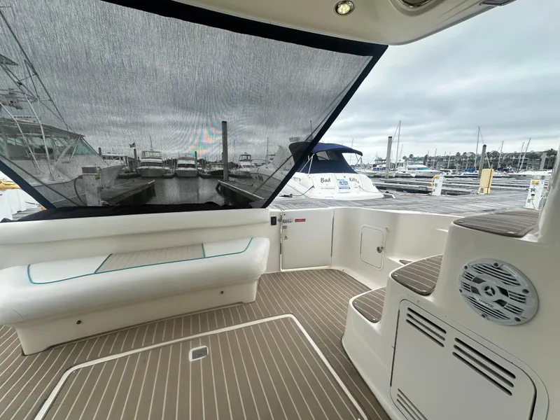 Slide: The Image of 1997 Sea Ray 400 Sedan Bridge yacht interior with marina view, featuring seating and steps. - 9