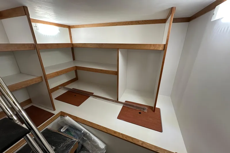 Slide: The Image of Interior storage space of 2025 Sabre 48 Salon Express yacht, featuring wooden shelves. - 16