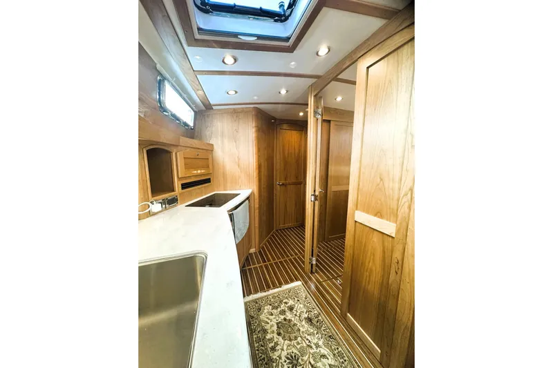Slide: The Image of 2025 Sabre 48 Salon Express interior with wood finish and modern lighting. - 18