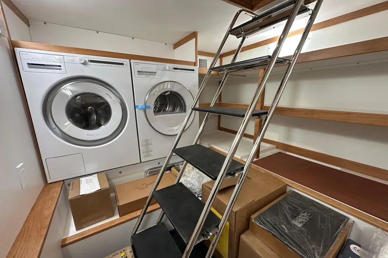 Slide: The Image of Laundry room with washer, dryer, metal ladder, and wooden shelves on a Sabre 48 Salon Express. - 4