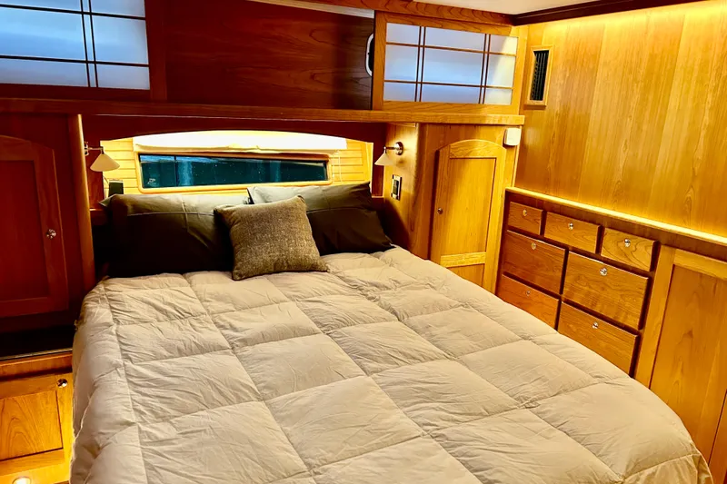Slide: The Image of Luxurious bedroom interior of 2025 Sabre 48 Salon Express yacht, featuring elegant wood finishes. - 7