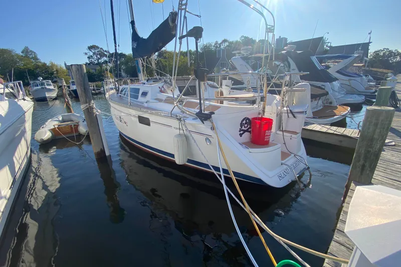 The Image of 1994 Hunter 33.5 sailboat docked at marina, sunny day, surrounded by other boats. - 0
