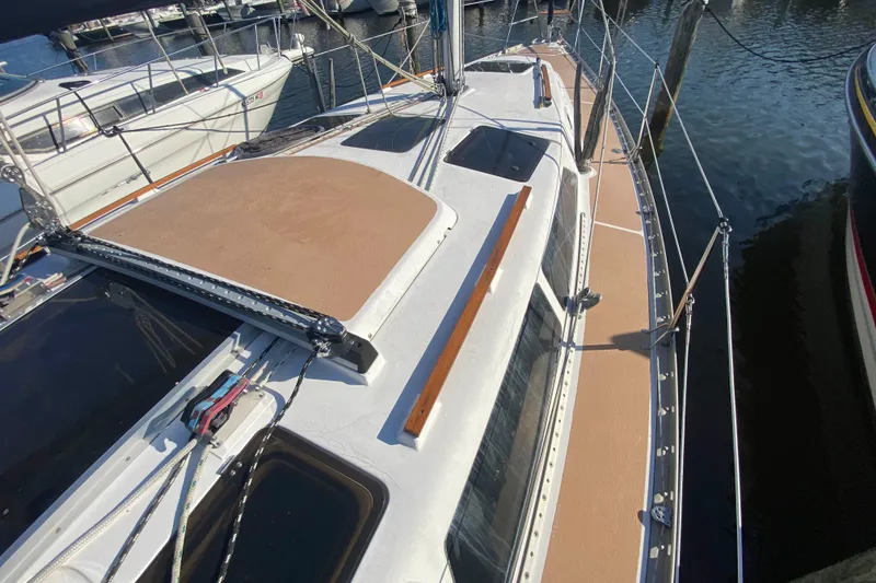 Slide: The Image of 1994 Hunter 33.5 sailboat docked at marina, showcasing deck and rigging. - 2
