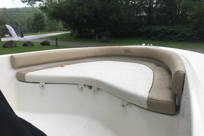 Slide: The Image of 2026 Pioneer 180 Islander boat with cushioned seating, outdoors in a lush green setting. - 10