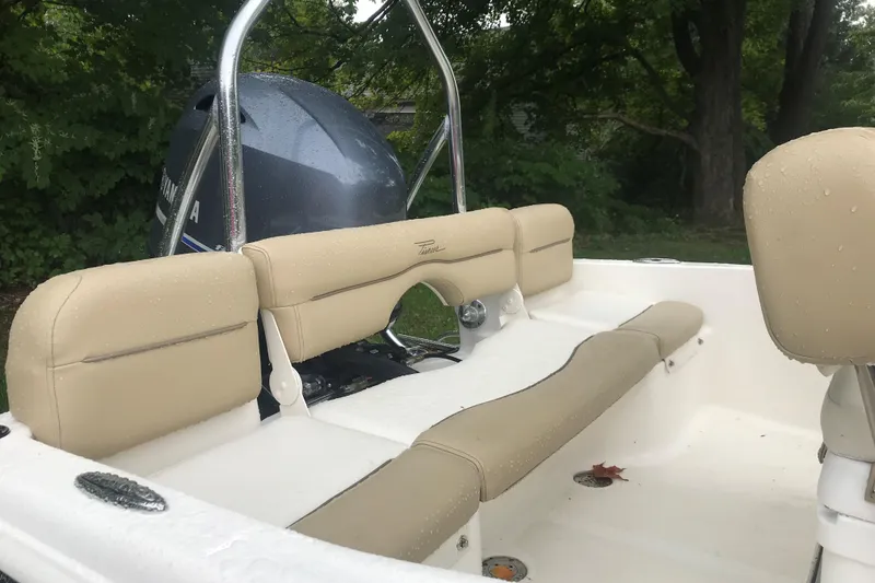 Slide: The Image of 2026 Pioneer 180 Islander boat interior with beige seating and Yamaha engine, outdoors. - 11