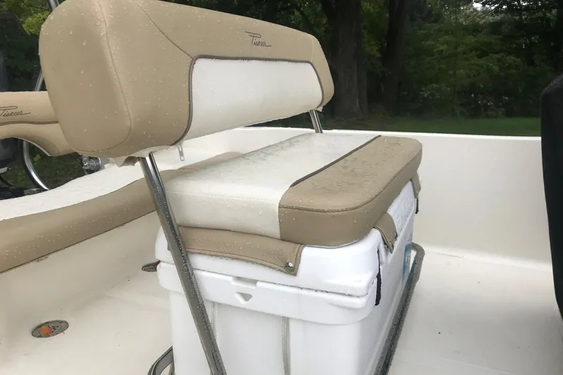 Slide: The Image of 2026 Pioneer 180 Islander boat seat with beige and white upholstery, featuring a cooler underneath. - 12