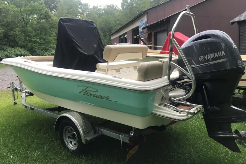 Slide: The Image of 2026 Pioneer 180 Islander boat with Yamaha motor on trailer, parked on grass. - 5