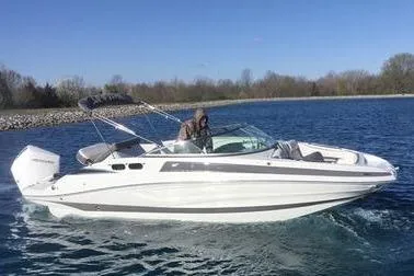 The Image of 2024 Crownline Eclipse E240 XS boat cruising on a clear blue lake. - 1