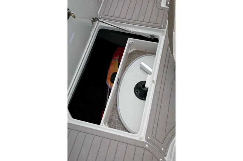 Slide: The Image of 2024 Crownline Eclipse E240 XS boat storage compartment with table and gear. - 12