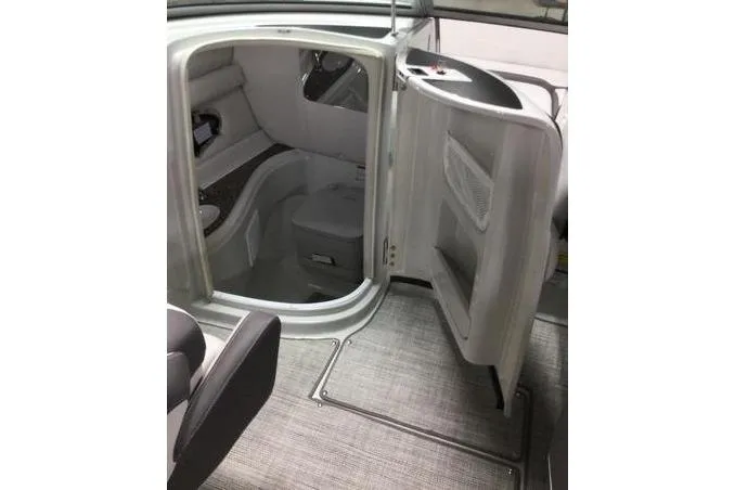 Slide: The Image of 2024 Crownline Eclipse E240 XS boat interior with open door and seating area. - 14