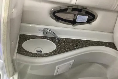 Slide: The Image of 2024 Crownline Eclipse E240 XS boat interior with sink and porthole window. - 15
