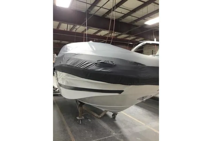 Slide: The Image of 2024 Crownline Eclipse E240 XS boat covered in storage facility. - 17