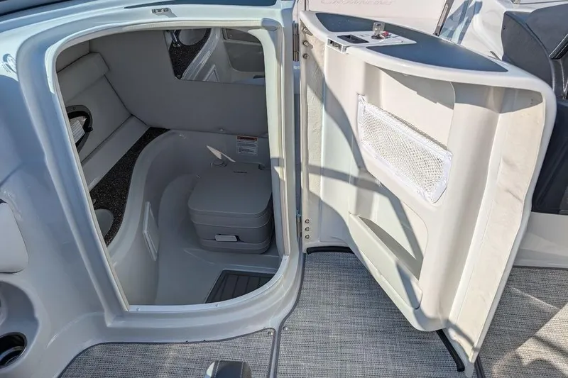 Slide: The Image of 2024 Crownline Eclipse E240 XS boat interior with compact restroom and storage. - 22