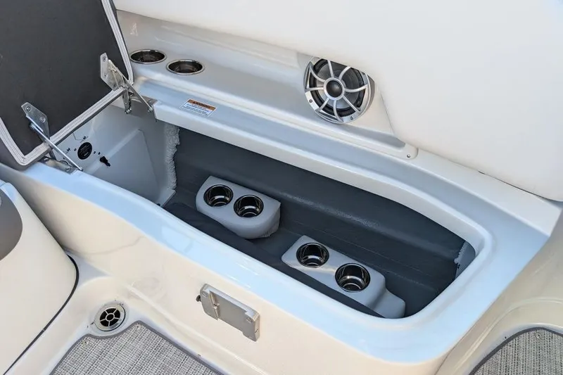 Slide: The Image of 2024 Crownline Eclipse E240 XS boat storage compartment with cup holders and speaker. - 27