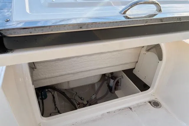 Slide: The Image of 2026 Robalo R230 Center Console boat storage compartment with open hatch. - 18