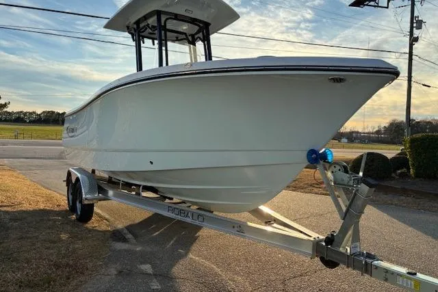 Slide: The Image of 2026 Robalo R230 Center Console boat on trailer, parked outdoors. - 4